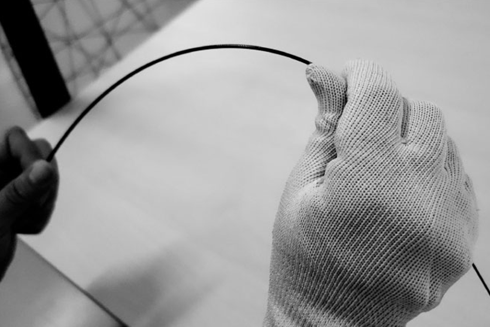 グローブをはめた職人が手でブランクを曲げて検査する工程